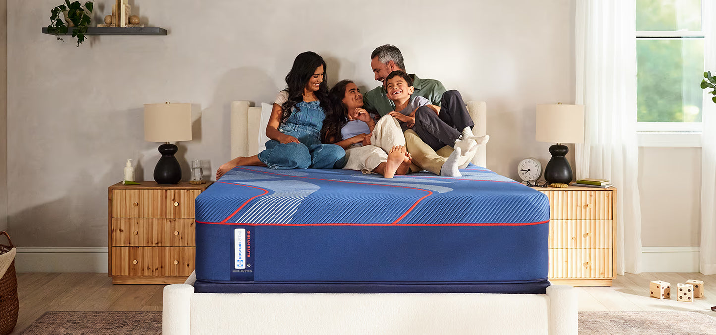Family sitting on a mattress in a bedroom setting