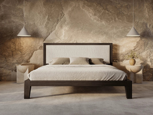 Bedroom with a wooden bed against a stone wall