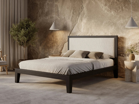 Bedroom with a wooden bed frame, white bedding, and decorative pillows against a textured wall.