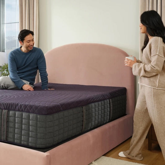 Man and woman enjoying a Purple mattress in a bedroom setting.