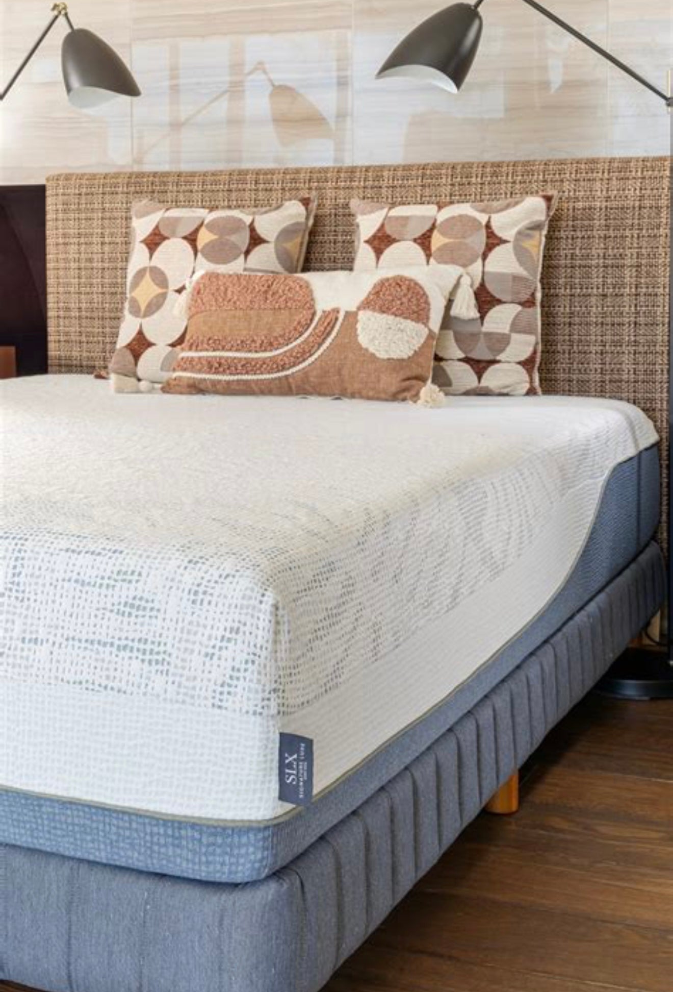 Gray mattress with decorative pillows on a bed in a bedroom setting