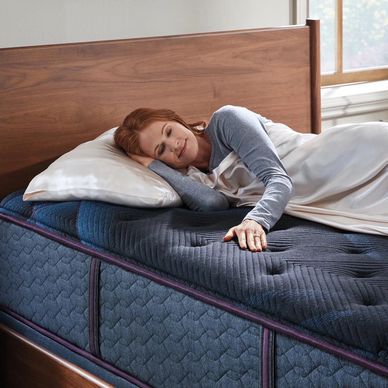 Woman lying on a mattress in a bedroom