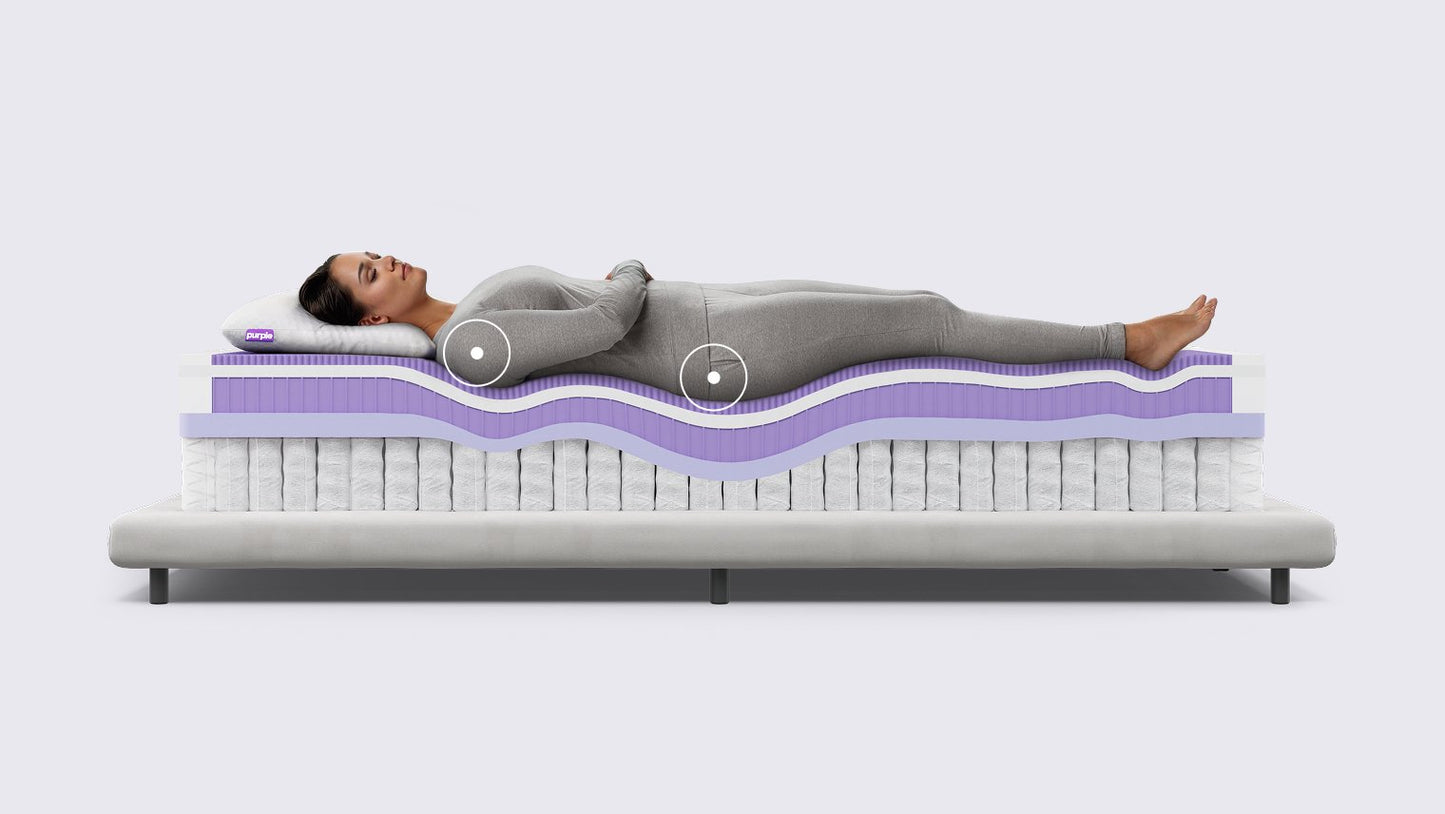 Woman lying on a mattress with a cross-sectional view showing its layers.