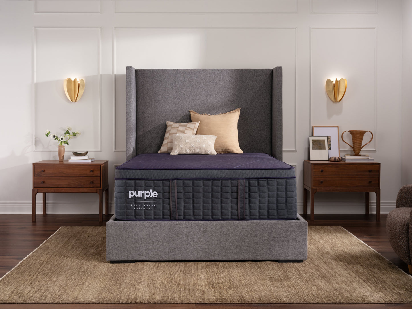 Purple luxury mattress in a bedroom setting with gray headboard and wooden nightstands.