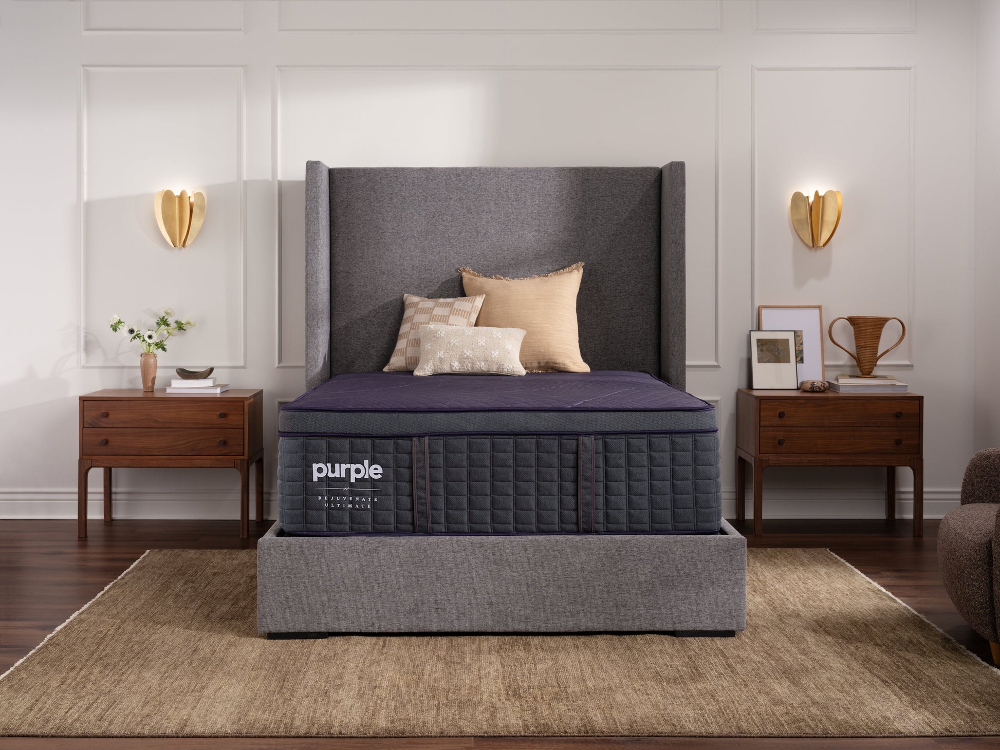 Purple luxury mattress in a bedroom setting with gray headboard and wooden nightstands.