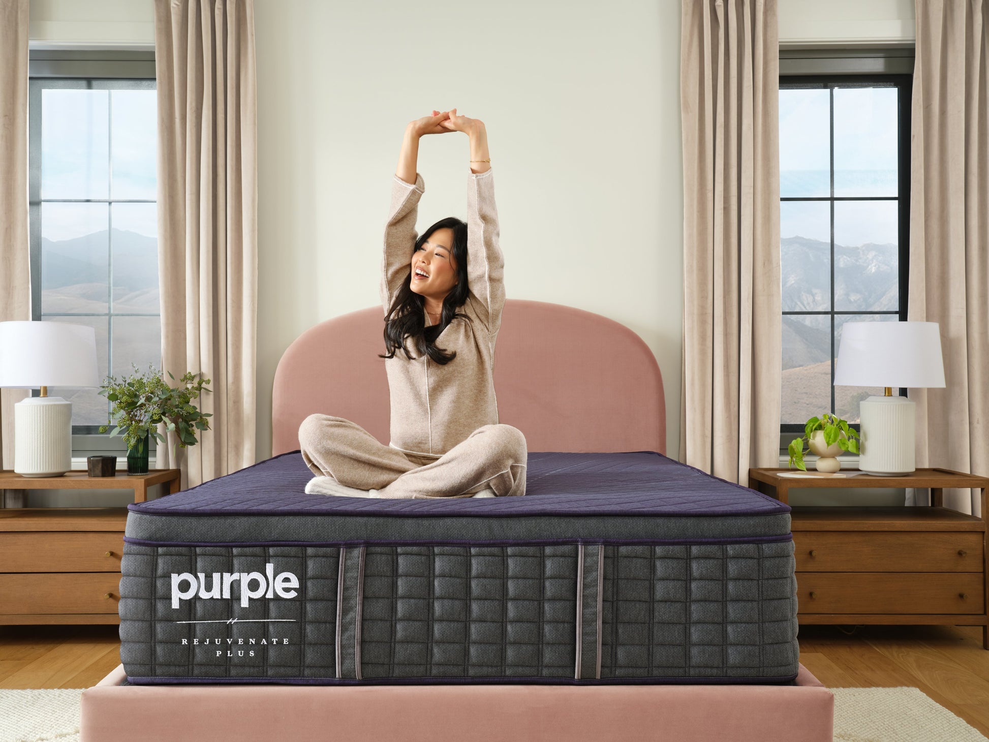 Woman sitting on a purple mattress in a bedroom