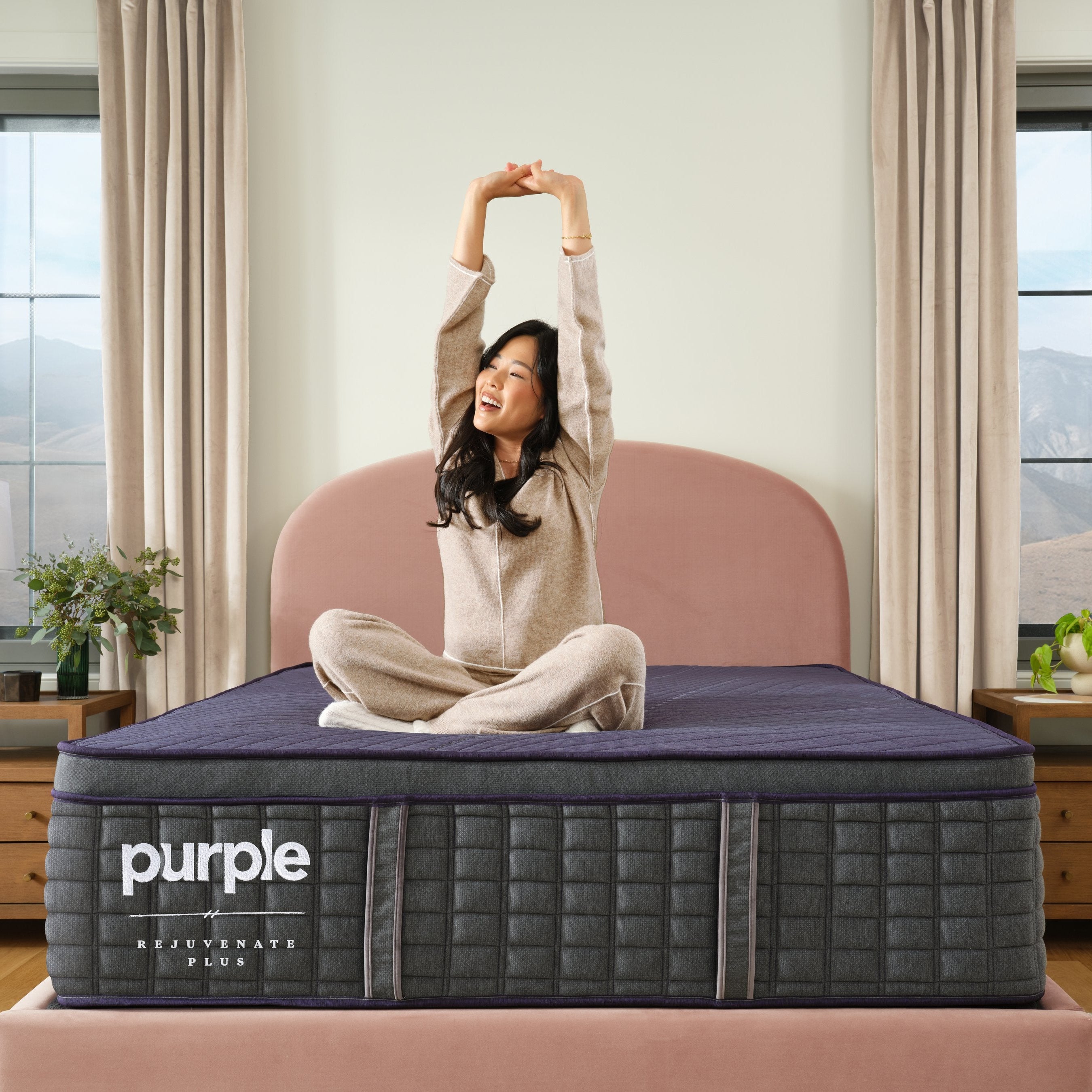 Woman sitting on a purple mattress in a bedroom