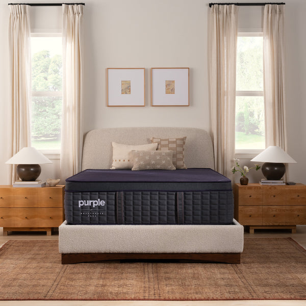 Purple Rejuvenate Plus mattress in a bedroom setting with a bed, nightstands, and decor.