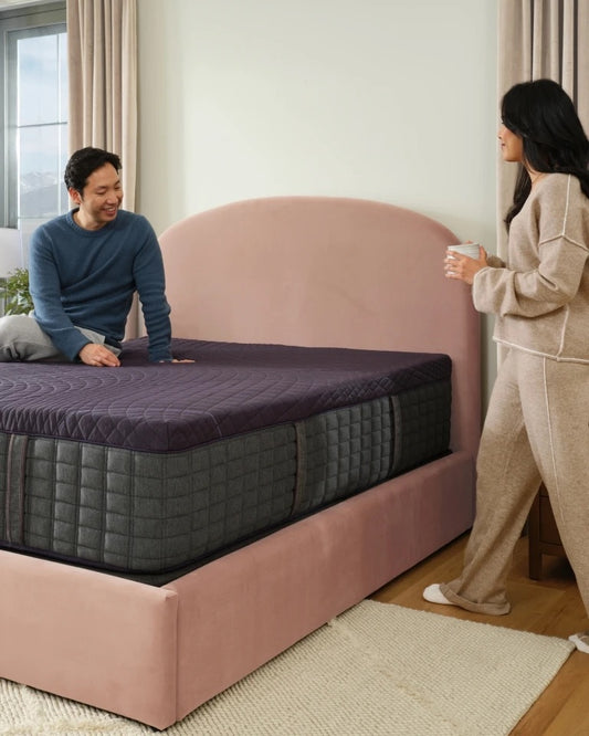 Man and woman enjoying a Purple mattress in a bedroom setting.