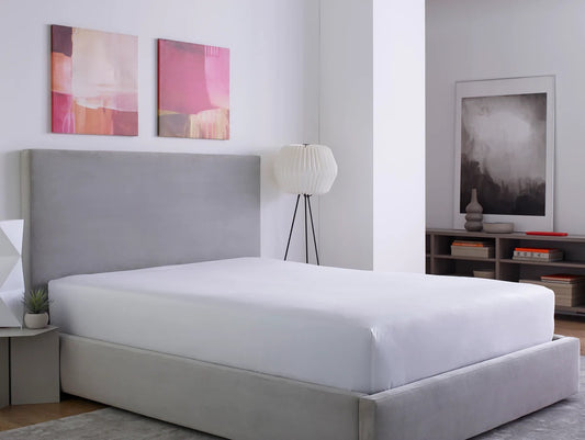 Bedroom with a gray bed and white mattress protector