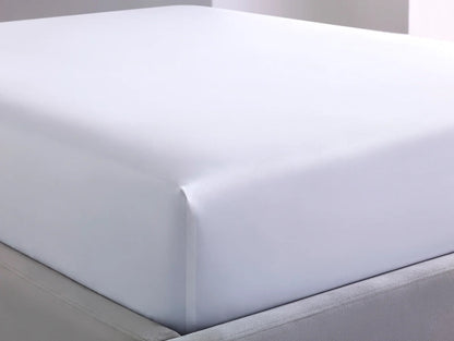 White mattress protector on a bed with a neutral background