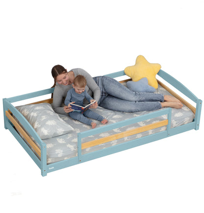 Woman and child lying on a blue children's bed with star-shaped pillow
