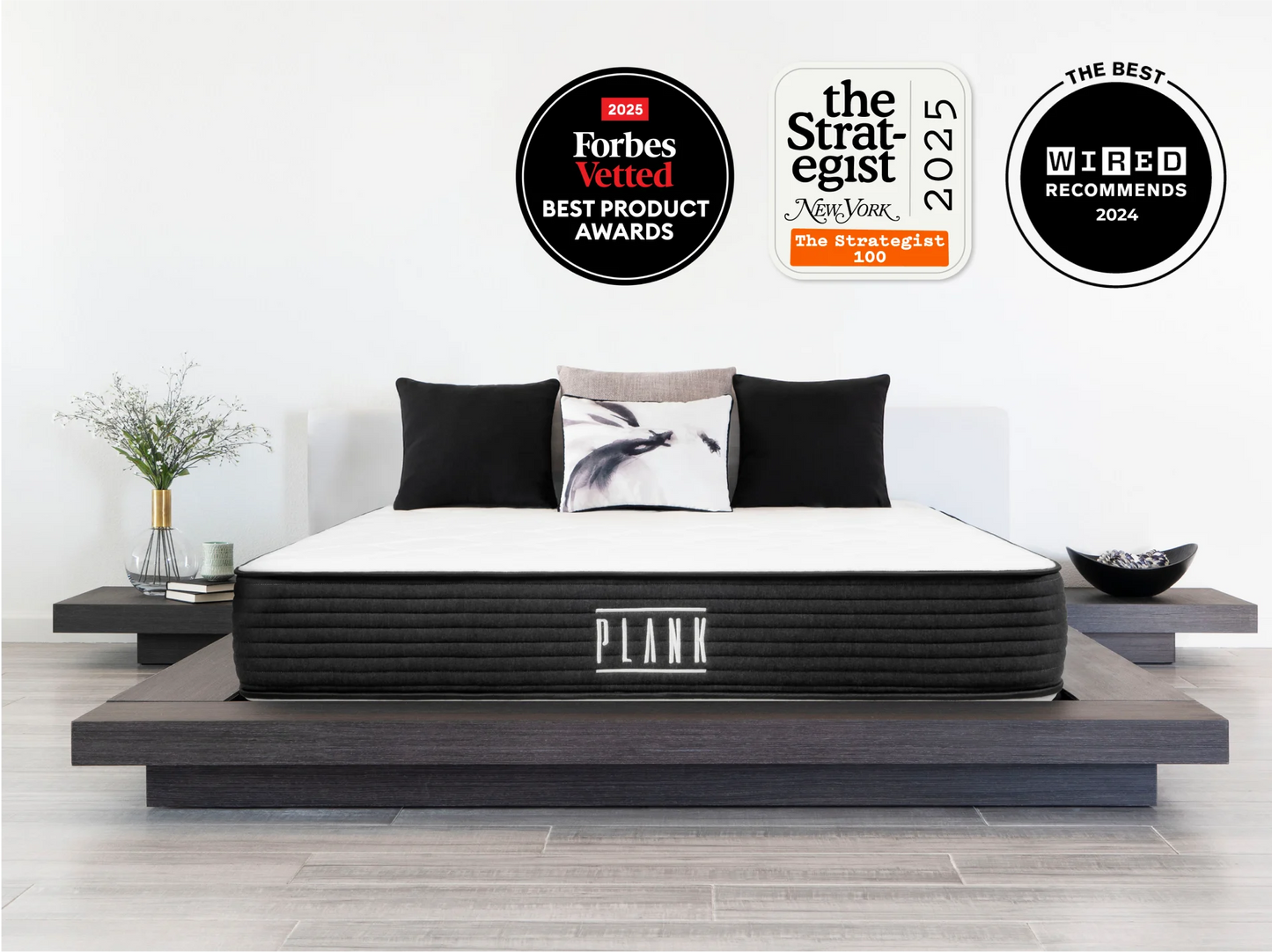 Mattress on a platform bed with award badges above it