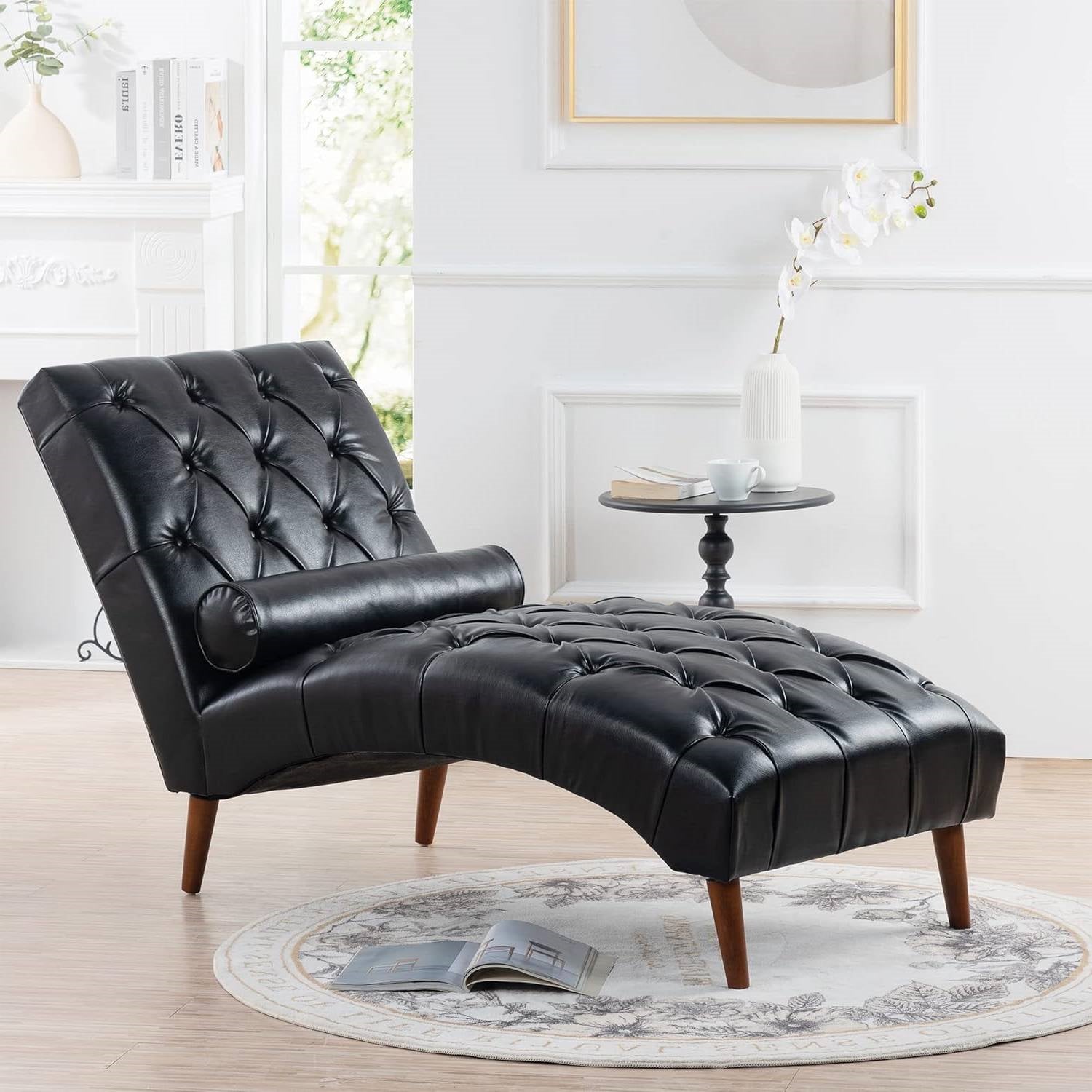 Black leather chaise lounge in a modern living room setting with a small table and decor items.