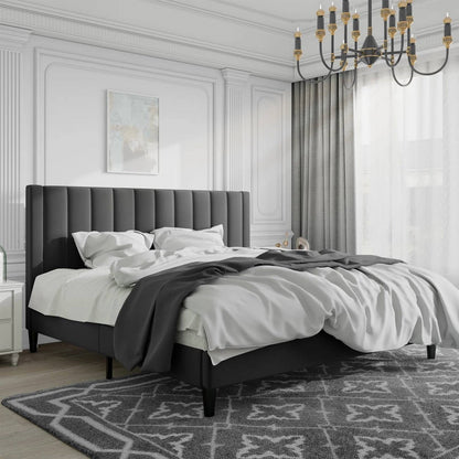 Modern bedroom with a black king size velvet upholstered bed, white bedding, and decorative rug.