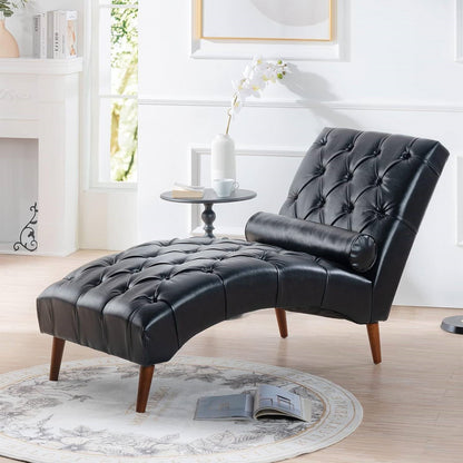Black leather chaise lounge in a living room setting with a fireplace and table.