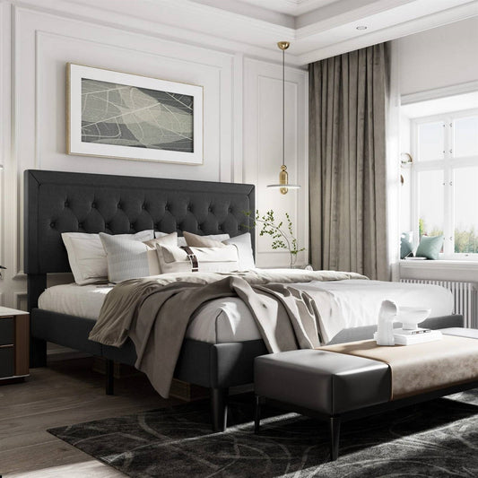 Modern bedroom with a king size black upholstered bed, gray rug, and large window.