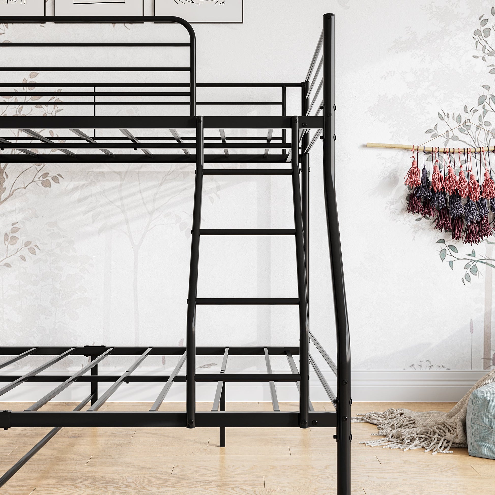 Twin over full size sturdy black metal bunk bed in a room with a white wall and wooden floor.