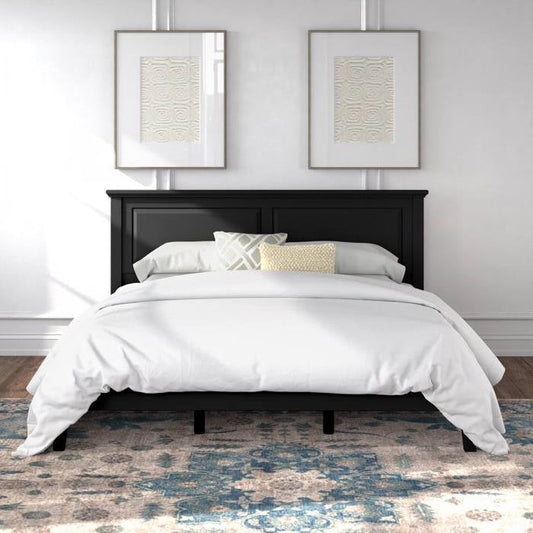 King size black wooden oak bed frame with white bedding in a room with two framed artworks on the wall.