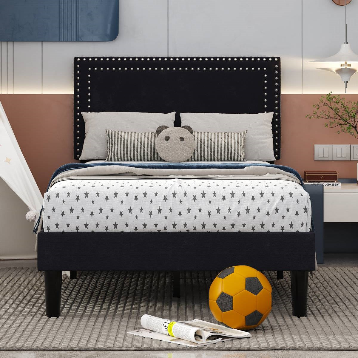 Bedroom with a bed featuring star-patterned bedding, a black headboard, and a soccer ball on the floor.