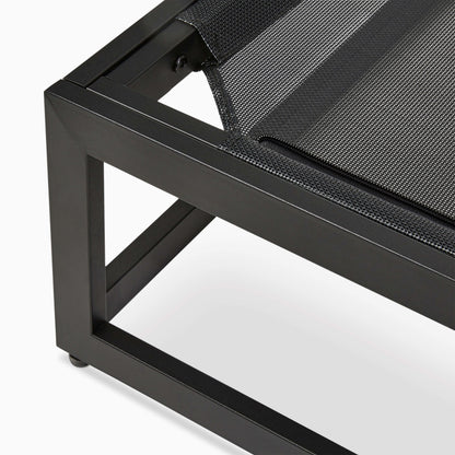 Close-up of a black metal dog bed with a black mesh surface on a white background
