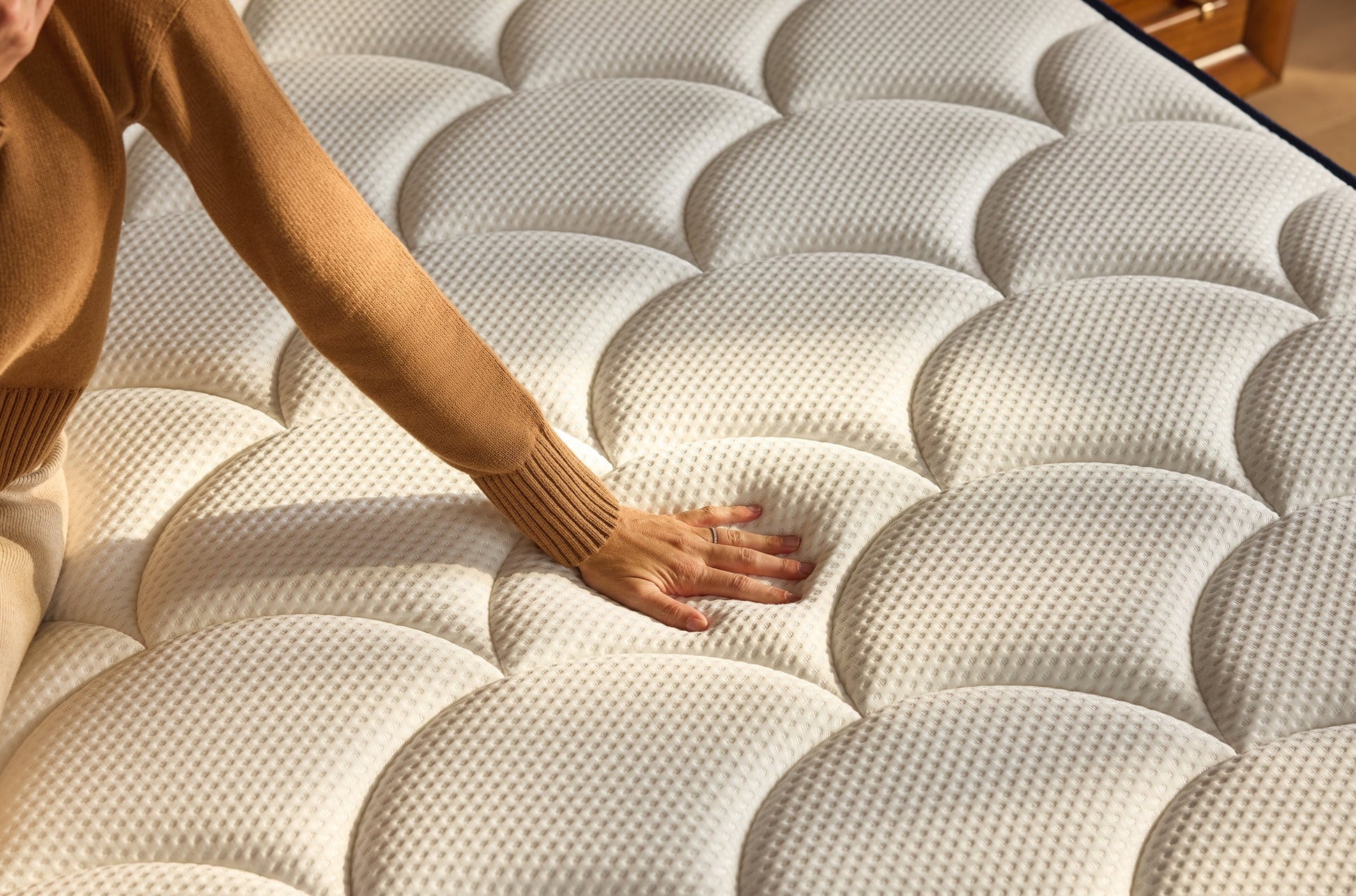 Person touching a textured mattress surface