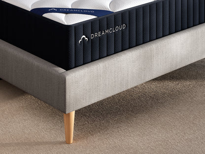 DreamCloud mattress on a bed frame with a neutral background
