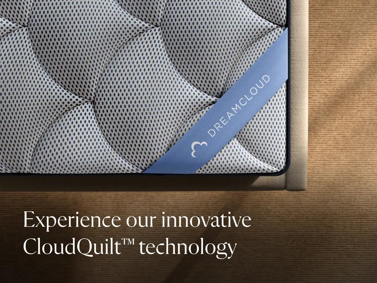 DreamCloud mattress with 'Experience our innovative CloudQuilt technology' text on a wooden bed frame.