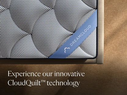 DreamCloud mattress with 'Experience our innovative CloudQuilt technology' text on a wooden bed frame.
