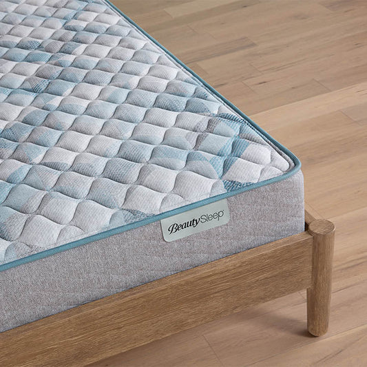 Gray quilted mattress on a wooden bed frame with 'BeautySleep' branding.