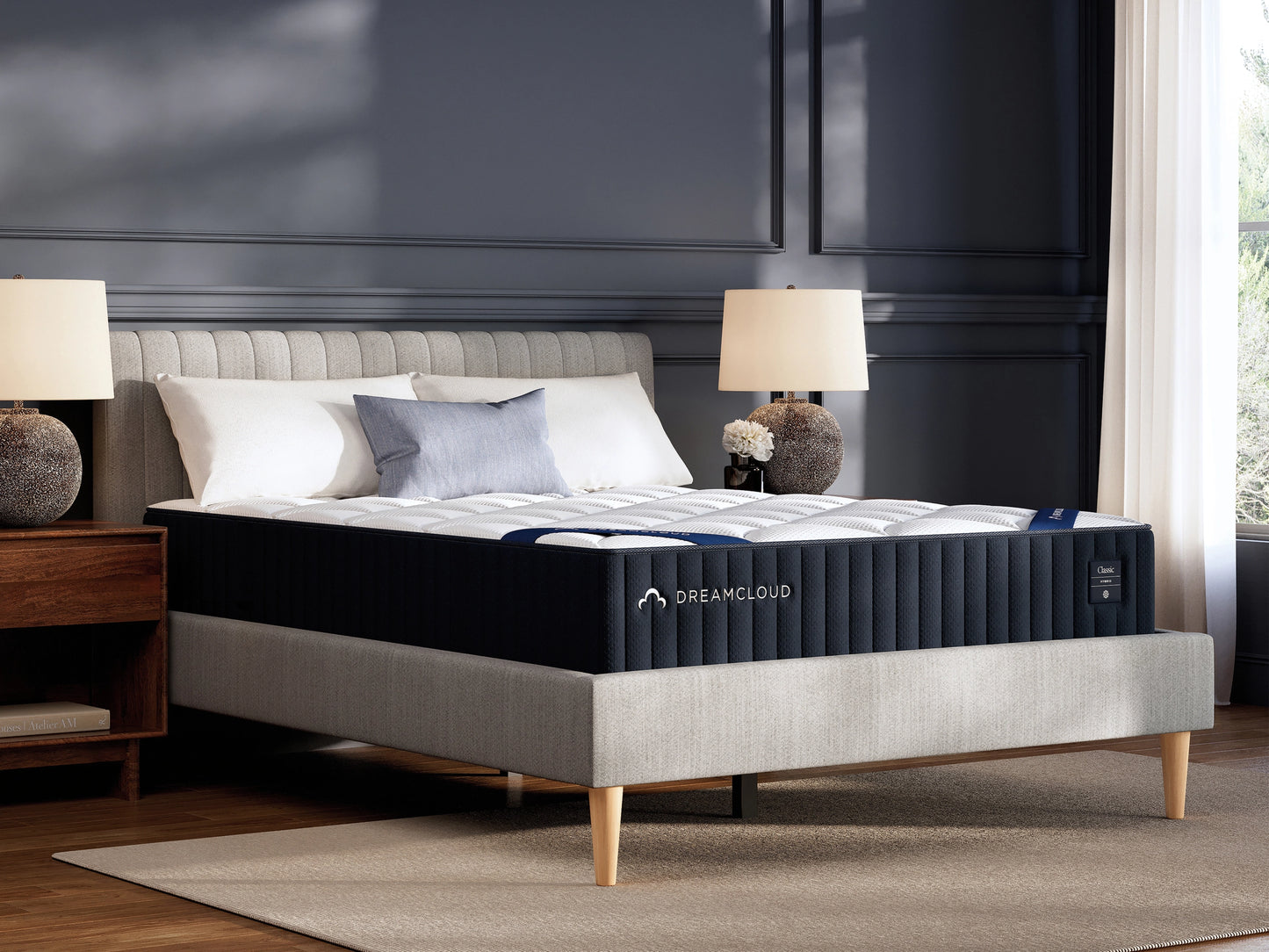 DreamCloud mattress on a bed in a bedroom setting with lamps and decor.