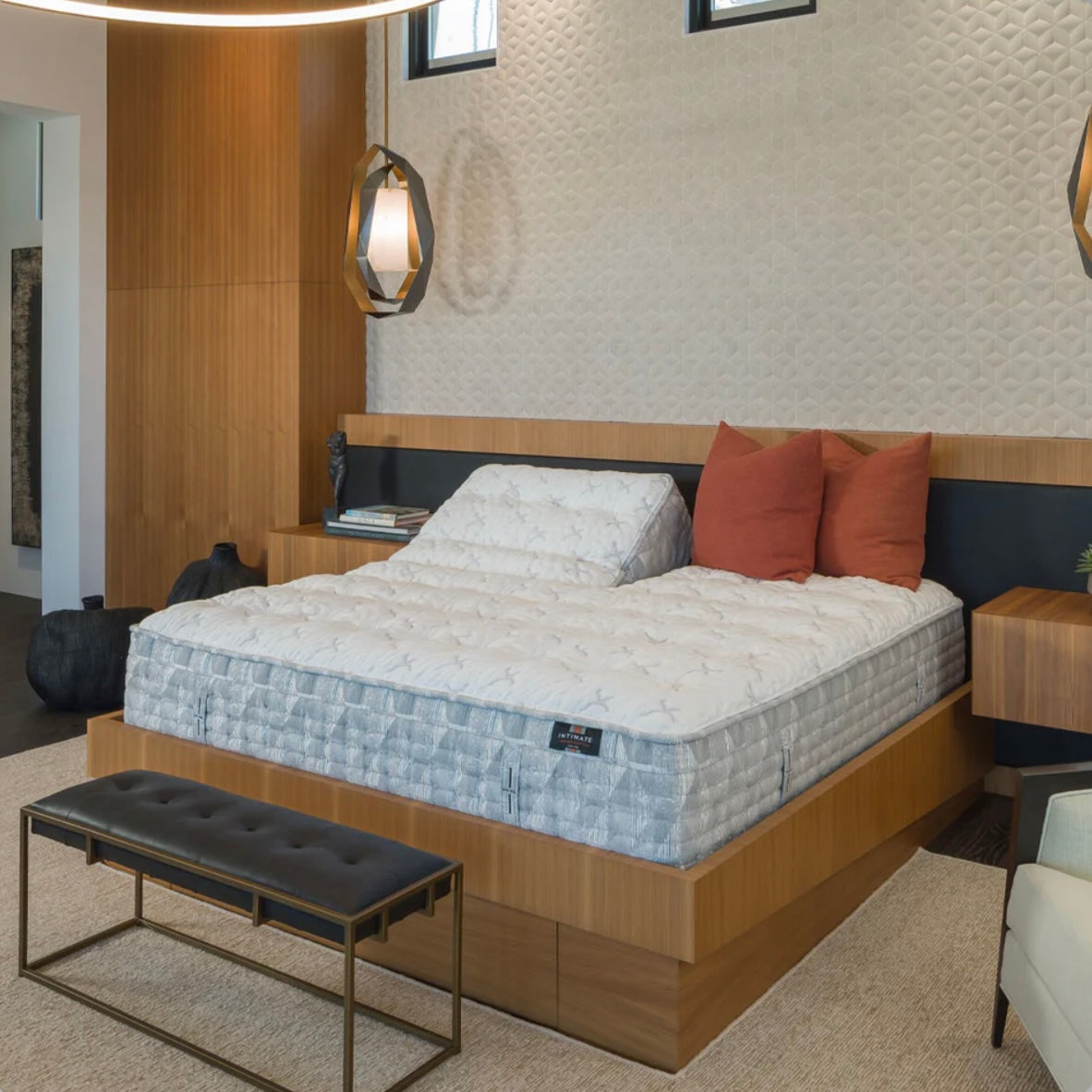 Bedroom with a bed featuring a flex head mattress and pillows, surrounded by furniture and decor.