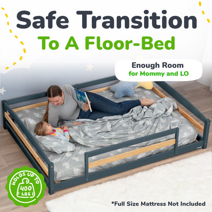Woman reading to a child in a floor bed with safety rails, suitable for a safe transition to a floor bed.