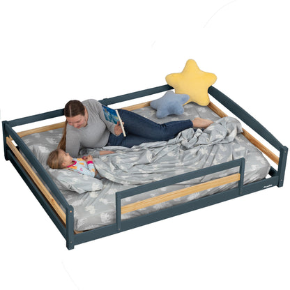 Woman reading to a child on a large bed with star and cloud decorations.