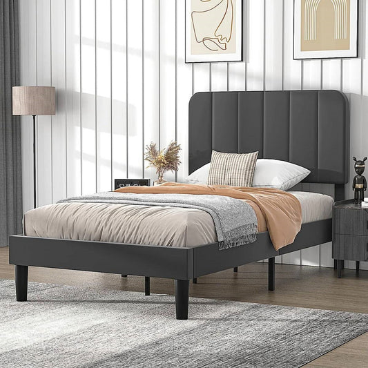 Gray twin upholstered bed in a modern bedroom with decor elements.