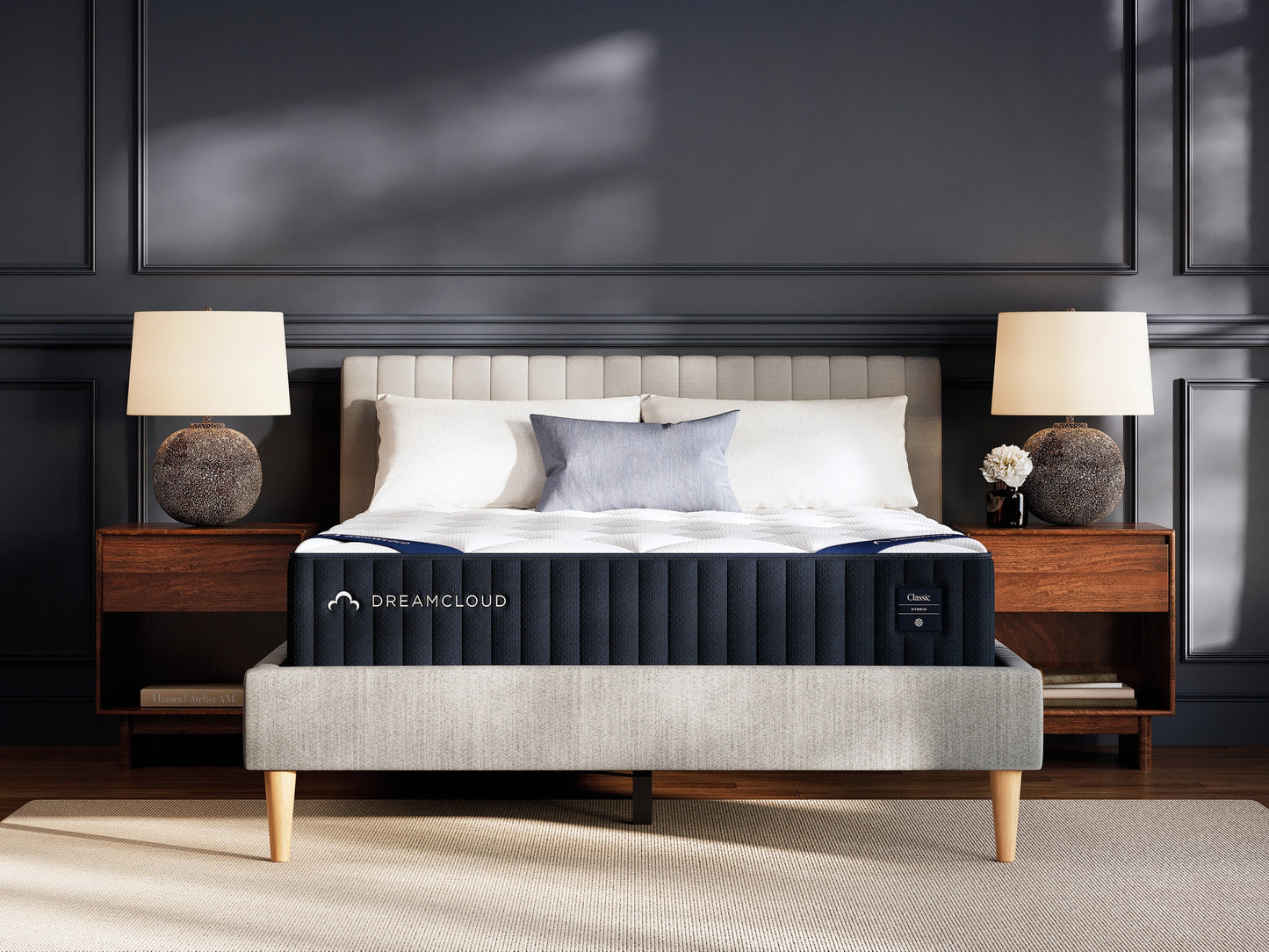 DreamCloud hybrid classic mattress on a bed in a bedroom setting with lamps and decor.