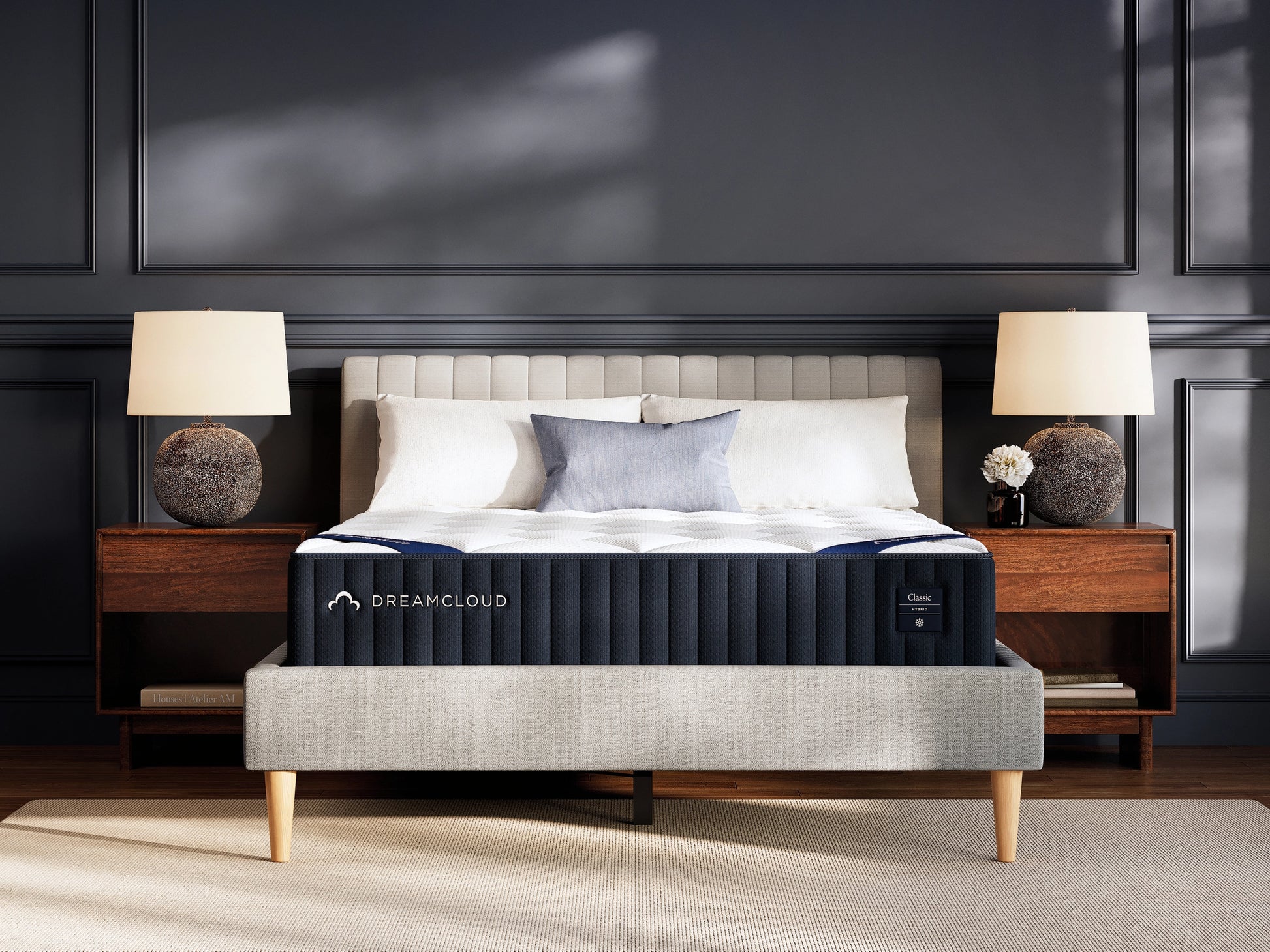 DreamCloud hybrid classic mattress on a bed in a bedroom setting with lamps and decor.