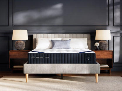 DreamCloud hybrid classic mattress on a bed in a bedroom setting with lamps and decor.