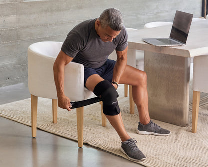 Man applying an infrared knee wrap