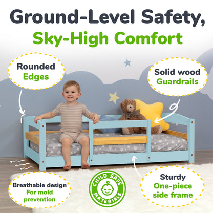 Child sitting on a blue bed with safety features highlighted, including rounded edges and solid wood guardrails.