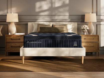 DreamCloud mattress on a bed in a bedroom setting with lamps and decor.