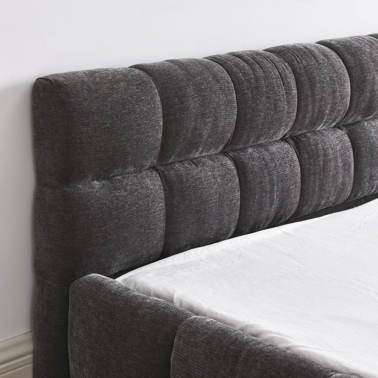 Luxury queen gray tufted headboard on a bed with white bedding.