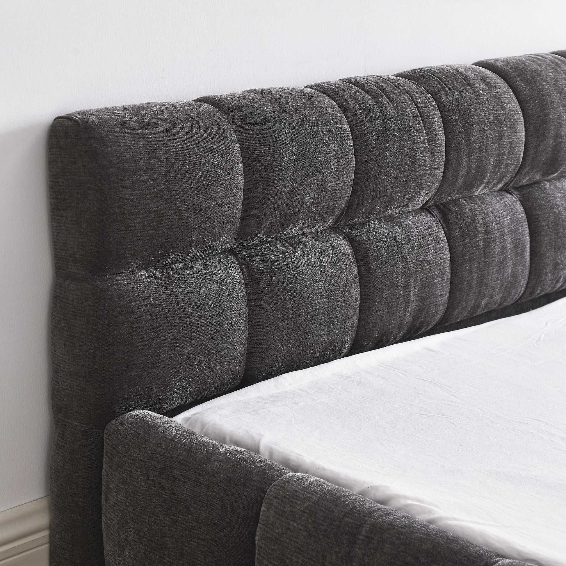 Luxury queen gray tufted headboard on a bed with white bedding.