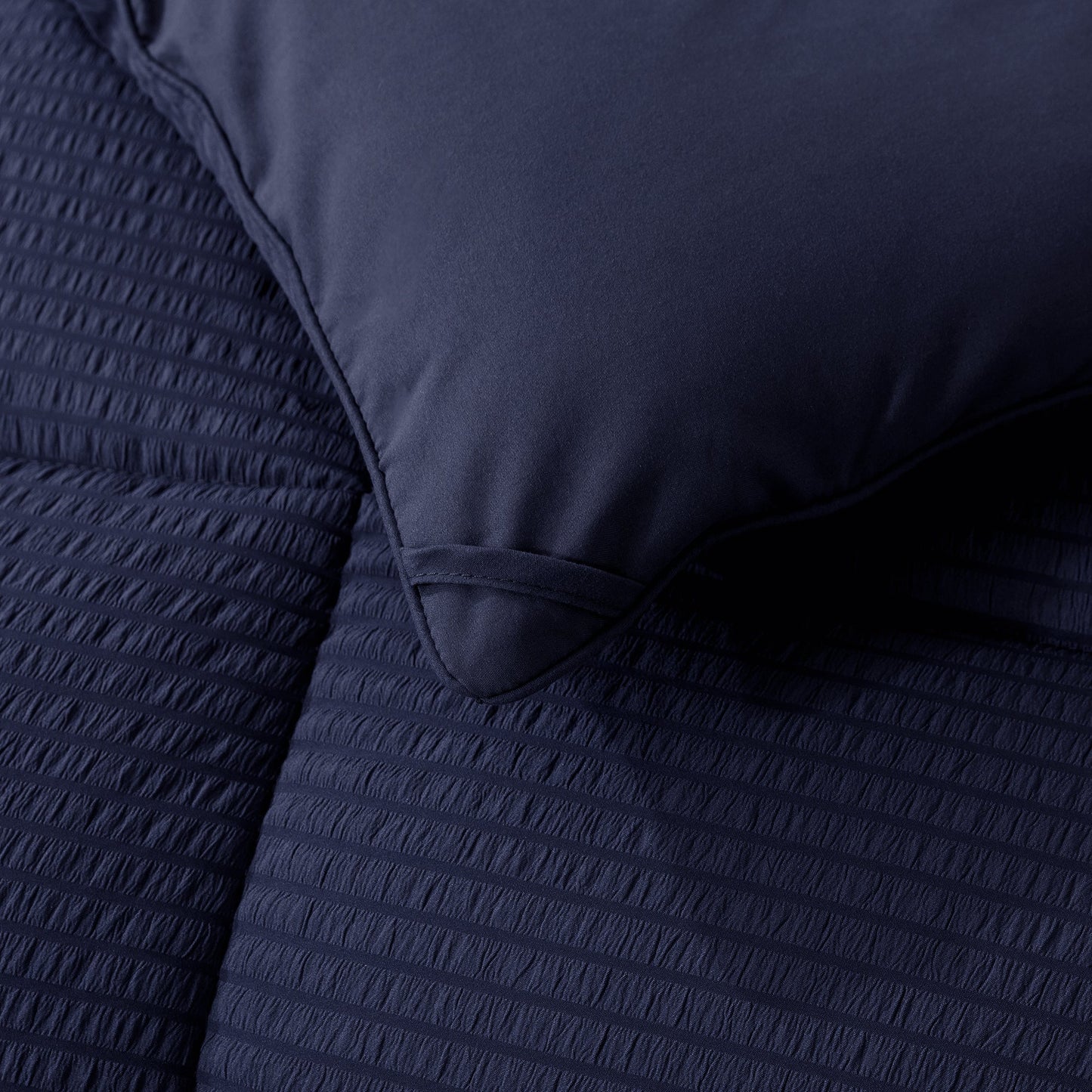 Navy blue textured bedding set with a pillow and duvet cover.