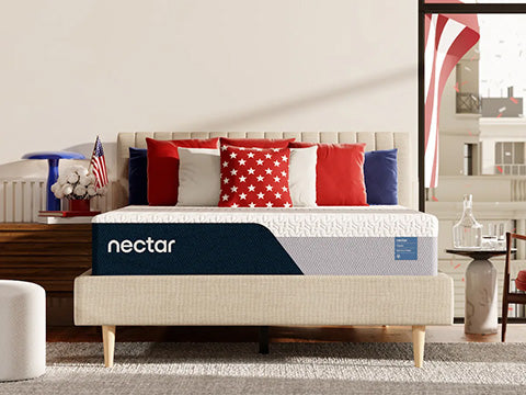 Nectar mattress in a bedroom setting with decorative pillows and an American flag.