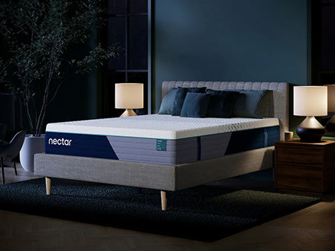 Nectar mattress on a bed in a dimly lit bedroom with two lamps and a plant.