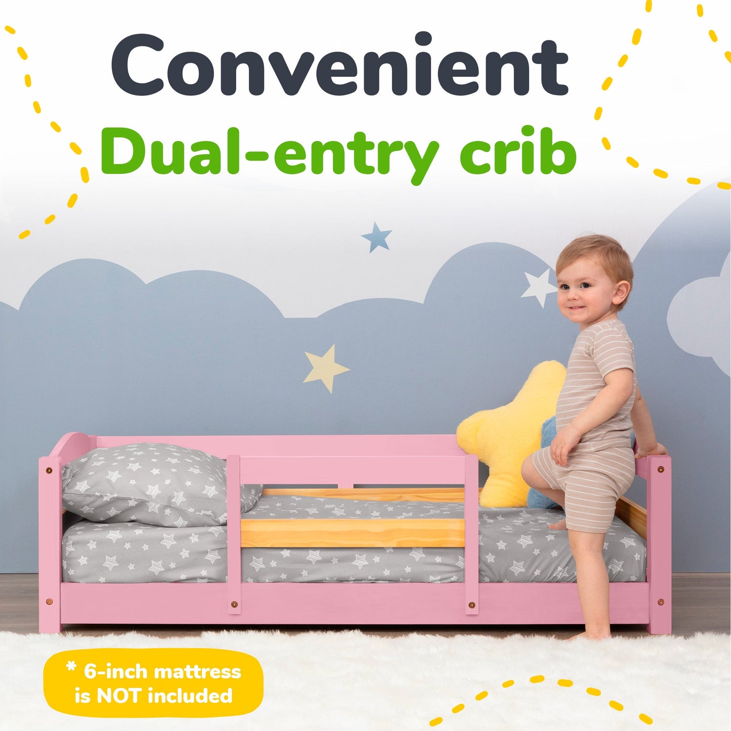 Pink dual-entry crib with a child standing on it, against a cloud-patterned wall.