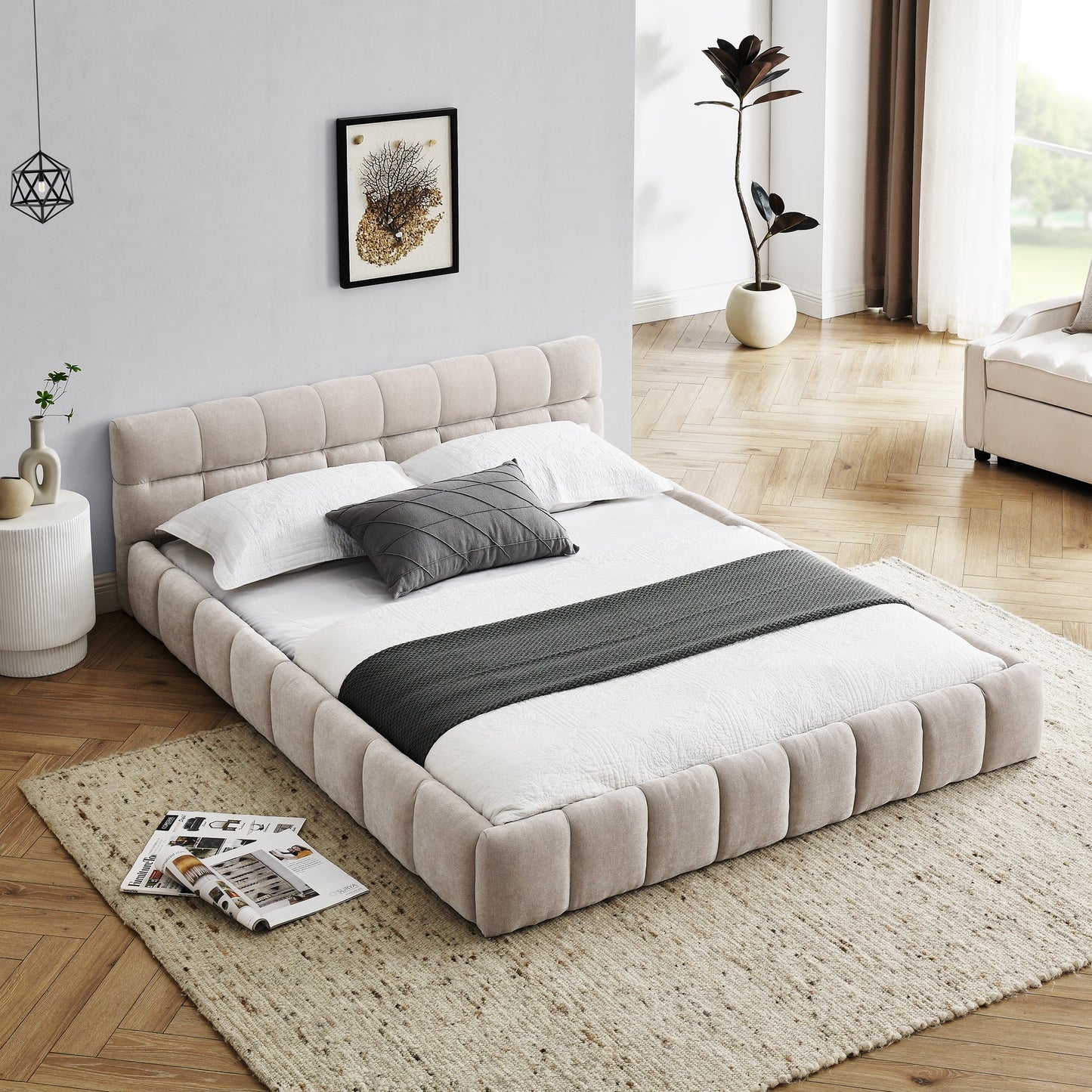 Beige upholstered bed in a modern bedroom with a rug and side table.