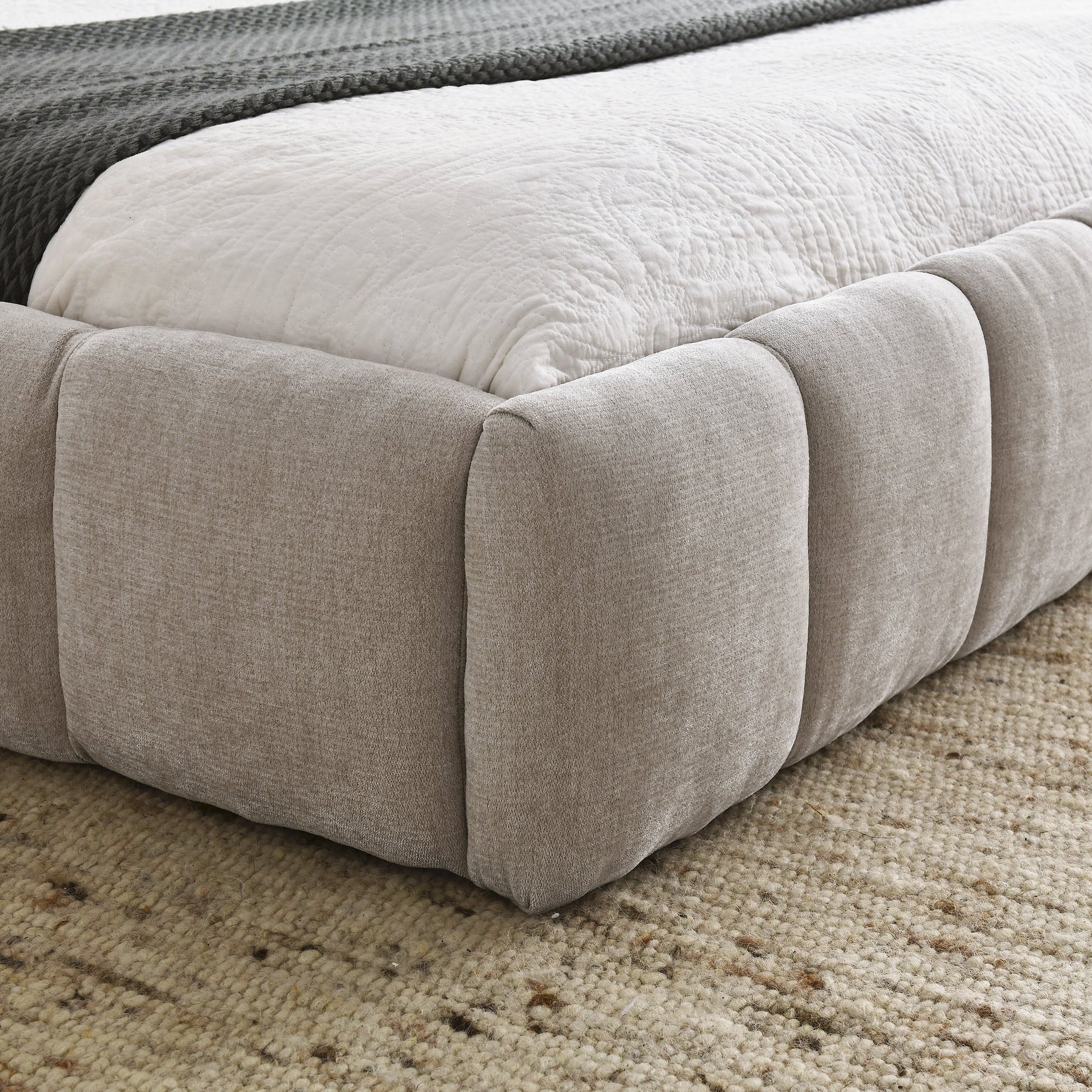 Close-up of a chinelle beige queen bed frame on a carpeted floor