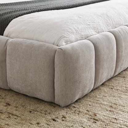 Close-up of a chinelle beige queen bed frame on a carpeted floor